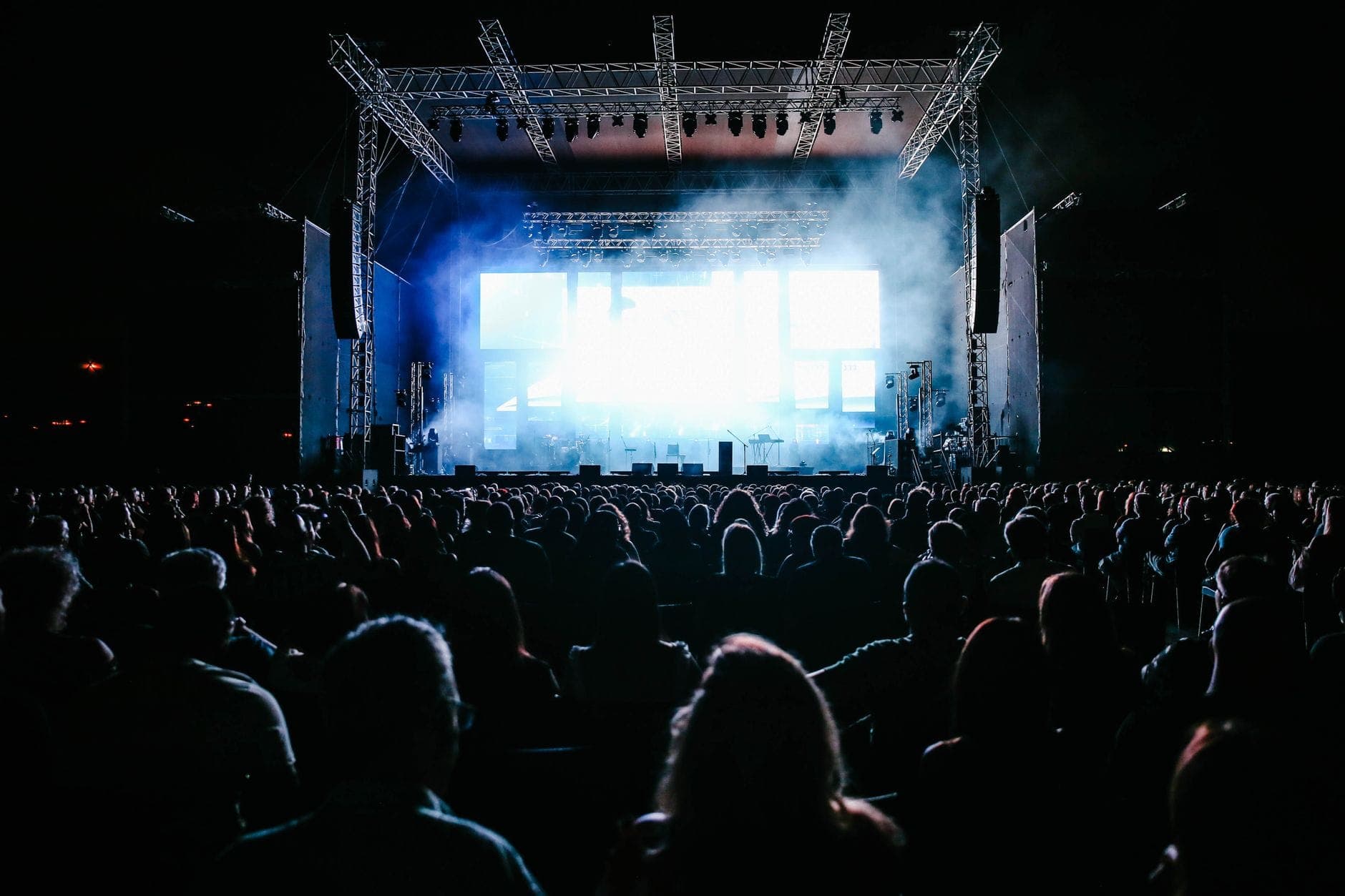 A large outdoor concert crowd under stage lights at night, the events Maxi Cab Perth runs pre-booked group pickups for