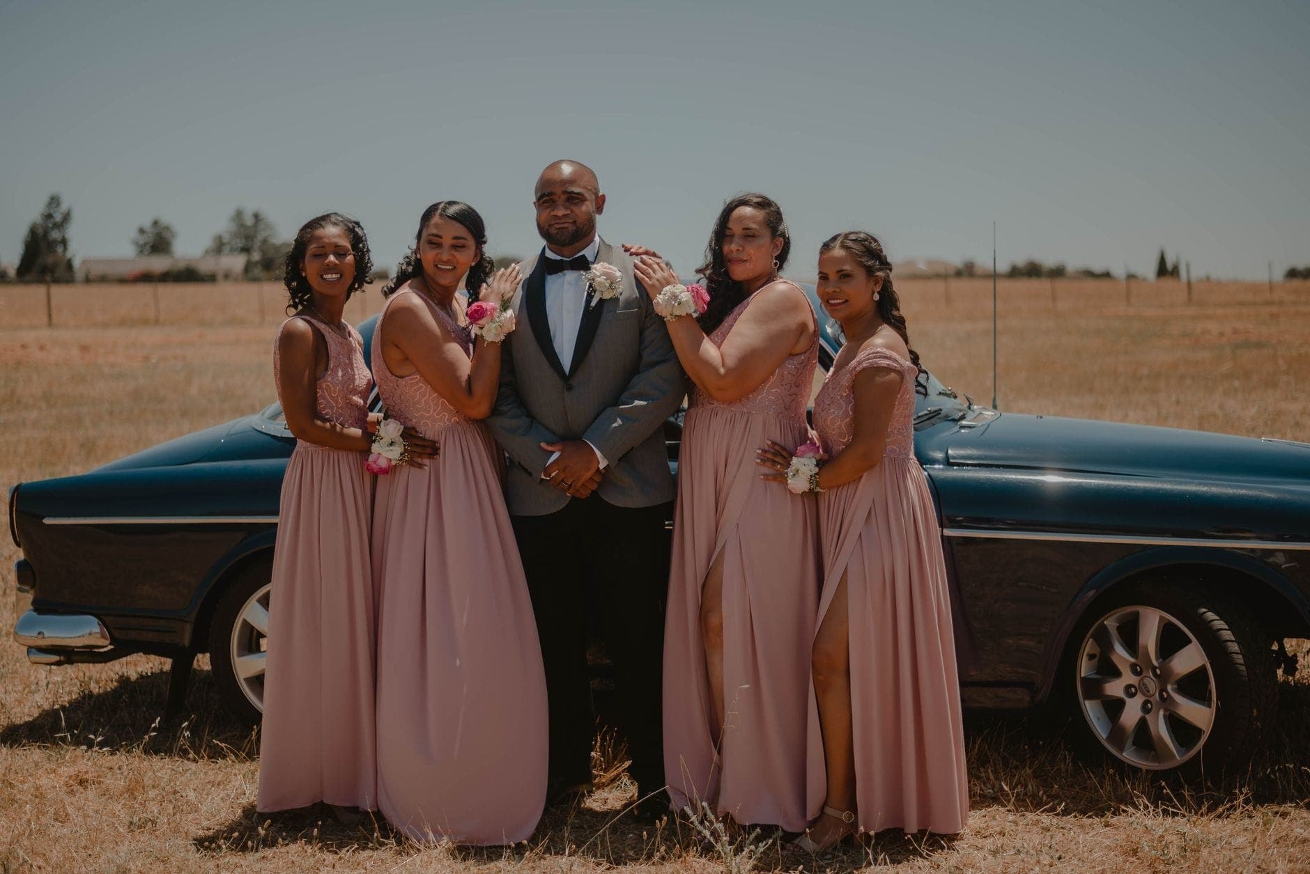 A groom and bridesmaids beside a car before the ceremony, the kind of bridal party a 13-seater maxi cab moves between Perth venues